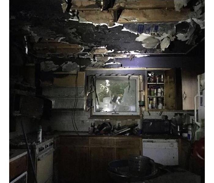kitchen with heavy smoke and soot damage to walls and appliances