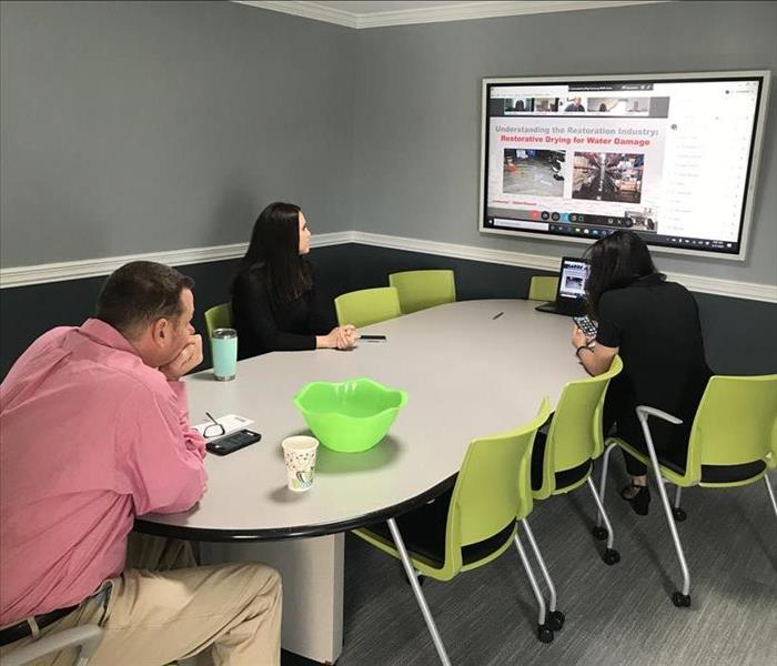 image of 3 SERVPRO workers hosting virtual CE class sitting around a table