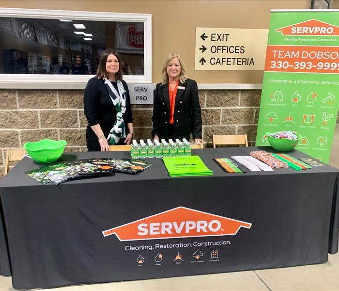two female SERVPRO HR employees behind marketing table at event