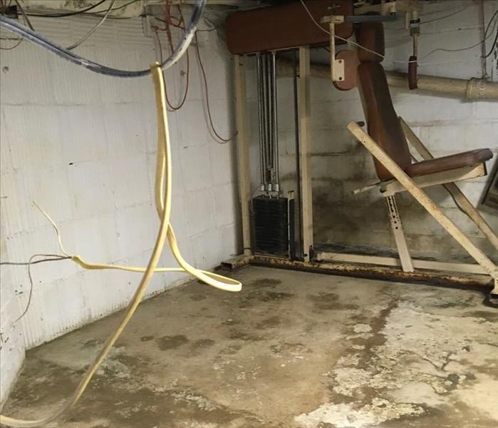 corner of concrete basement with clean floor and surrounding contents