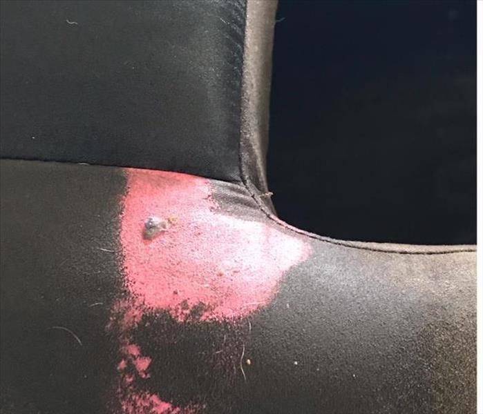 brown suede chair with a piece of pink gum in the lower left corner attached to the chair