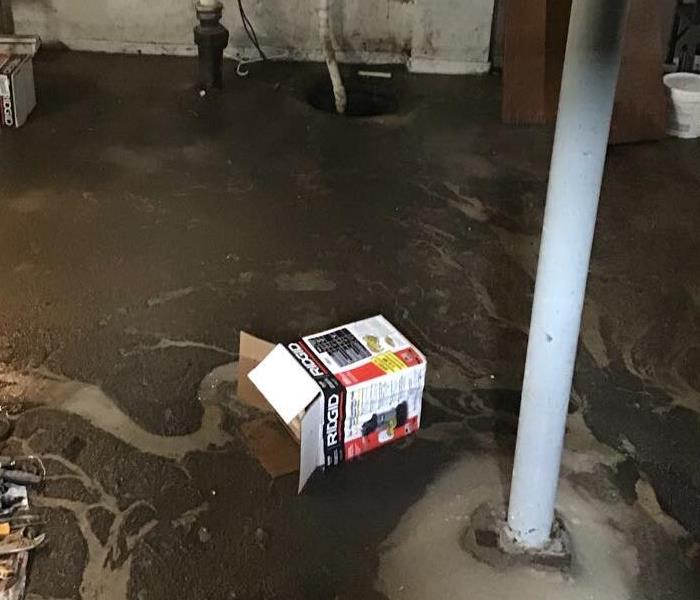 concrete basement floor with layers of sewage on the ground